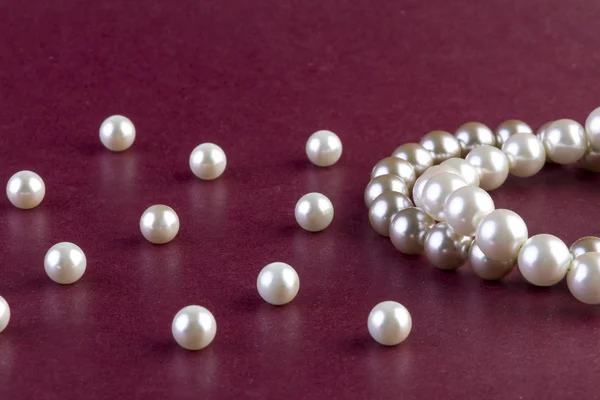 Colier de perle argintii si albe pe rosu inchis — Fotografie, imagine de stoc