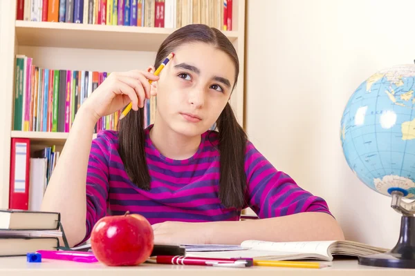 Little schoolgirl holding a pencil and thinking — Stock Photo, Image