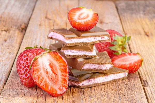 Chocolate with strawberry cream on wood — Stock Photo, Image
