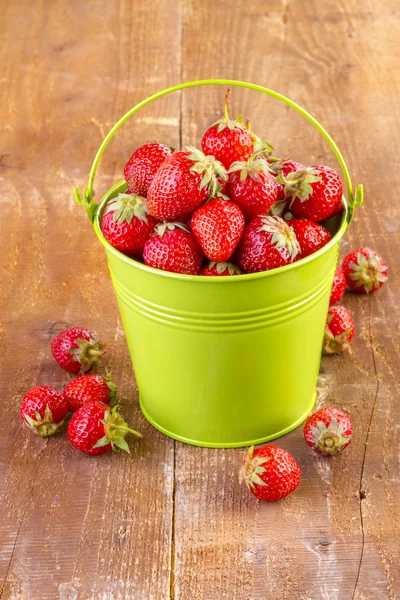 Strawberry in a green metal bucket on wood — Stock Photo, Image