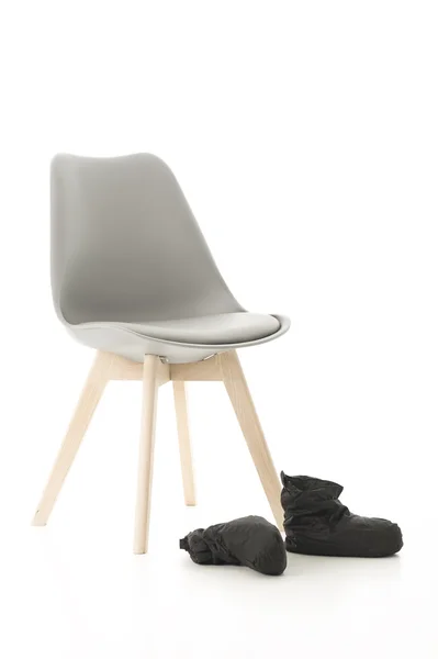 Cadeira de perna de madeira e botas pretas em branco — Fotografia de Stock