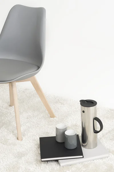 Servir café junto a una silla moderna Fotos de stock