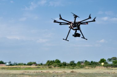 Gökyüzünde kamera olan uçan bir dron.