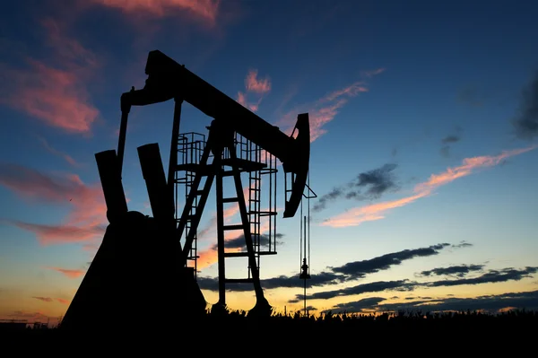 Silhouette of oil pump at dawn sky background — Stock Photo, Image
