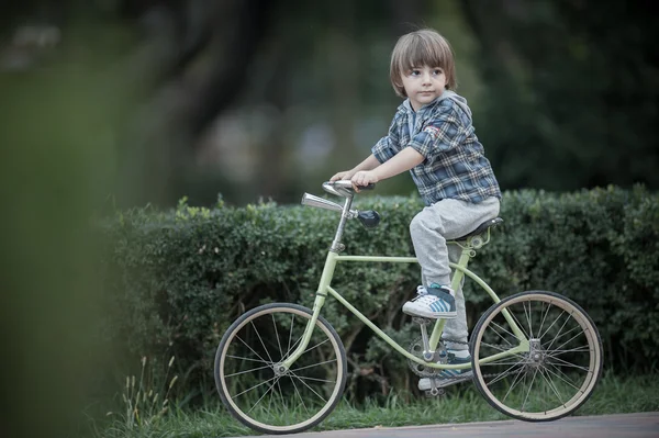 Menino feliz com bicicleta no parque de outono — Fotografia de Stock