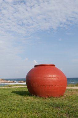 Yeşil çimenlerin üzerinde kırmızı büyük pot.