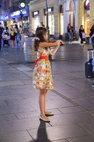 Una violinista joven, músico callejero que actúa en una plaza de Belgrado, la capital serbia —  Fotos de Stock