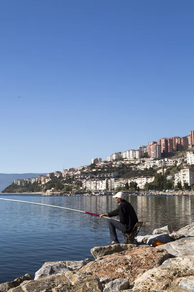 不明身份的男子在土耳其西南部伯萨的 gemlik 的 marmara sea 海岸捕鱼 — 图库照片