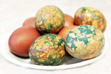 Beyaz tabakta yığın tarafından yerleştirilen renkli Paskalya yortusu yumurta