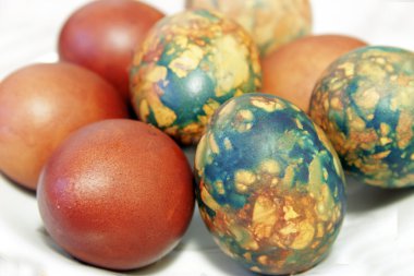 Beyaz tabakta yığın tarafından yerleştirilen renkli Paskalya yortusu yumurta