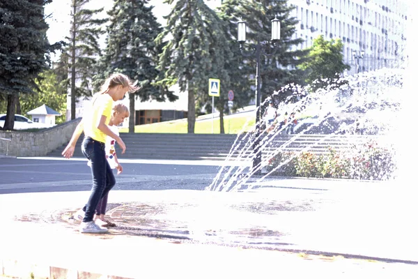 Дети возле брызгающегося фонтана в центре города — стоковое фото