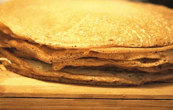 Stapel hausgemachter Pfannkuchen auf Holz-Kochbrett — Stockfoto