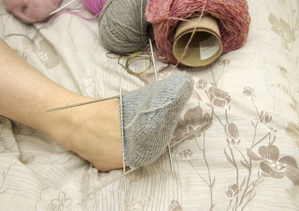 Frau Probiert Vor Hellem Hintergrund Eine Unfertige Graue Wollsocke Fuß — Stockfoto