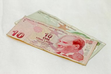 Beyaz arka planda 10 Türk lirası ve 20 kullanılmış Türk lirası para birimi var.