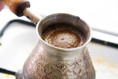 Sıcak, lezzetli bir kahve geleneksel olarak eski bir Türk 'ü sıcak yemek pişirme fırınına yerleştirir.