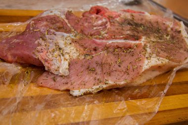 Kesme tahtasına baharat dökülmüş büyük taze biftek.