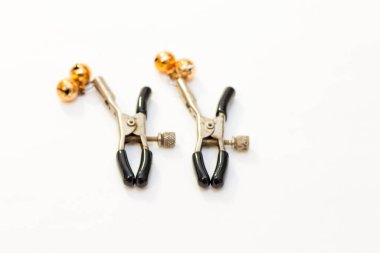 Beyaz arka planda izole edilmiş bir çift meme ucu kıskacı.