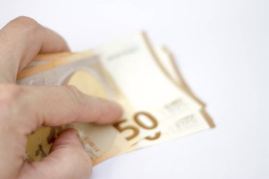Adam, beyaz arka planda 50 avroluk banknotlar tutuyor.