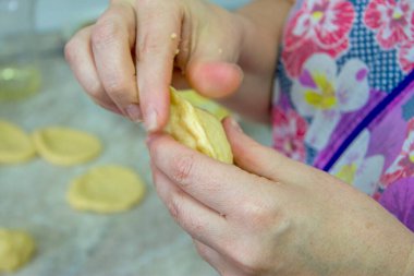 Kadın mutfağa patatesli ve soğanlı ev yapımı turta dolduruyor.