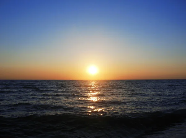 Puesta de sol sobre el mar de verano con pequeñas olas — Foto de Stock