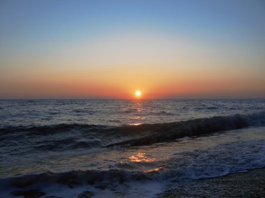 günbatımı üzerinde küçük dalgalar ile yaz deniz