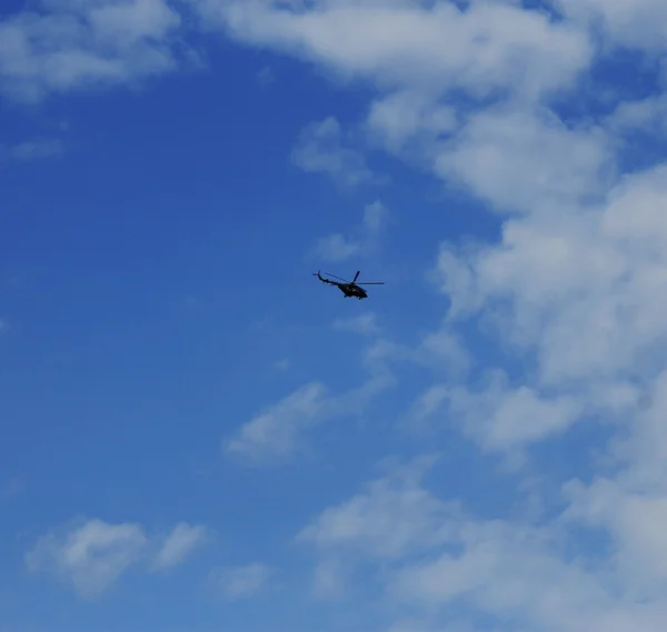 Вертолет летит в голубом небе с облаками — стоковое фото