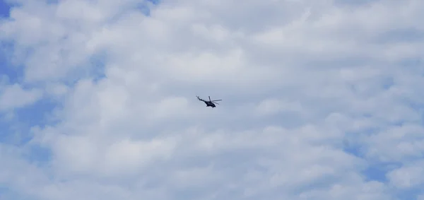 Vol d'hélicoptère dans le ciel bleu avec nuages — Photo