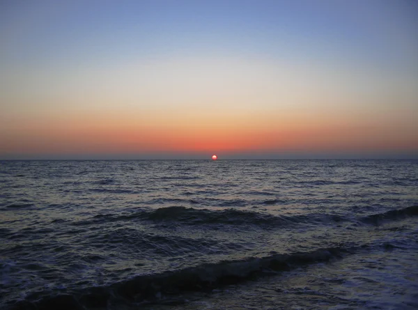 Puesta de sol sobre el mar de verano con pequeñas olas — Foto de Stock