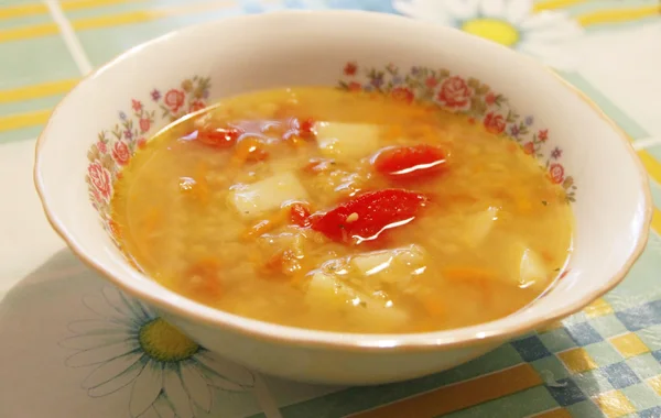 Tigela com uma sopa fresca na toalha de mesa na mesa — Fotografia de Stock