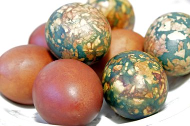 Beyaz tabakta yığın tarafından yerleştirilen renkli Paskalya yortusu yumurta