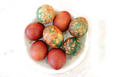 Beyaz tabakta yığın tarafından yerleştirilen renkli Paskalya yortusu yumurta