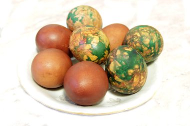 Beyaz tabakta yığın tarafından yerleştirilen renkli Paskalya yortusu yumurta