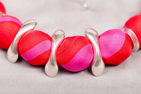 Collier de boules rouges et bagues argentées sur gris — Photo