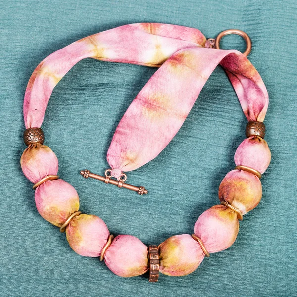Vista superior del collar de bolas de seda rosa en verde — Foto de Stock