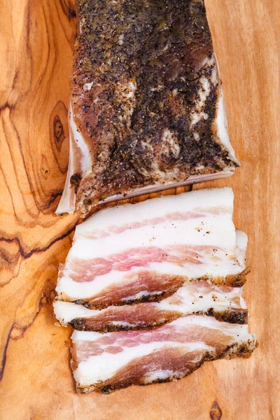 Top view of piece and few slices of bacon on board — Stock Photo, Image