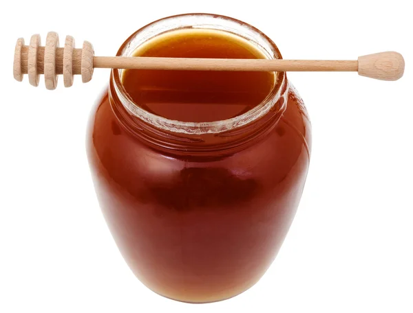Tarro de vidrio con miel marrón y palo de madera —  Fotos de Stock