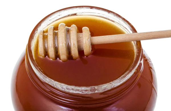 Träpinne på glasburk med honung på nära håll — Stockfoto