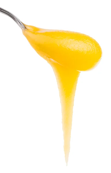 Yellow honey flows down from metal spoon close up — Stock Photo, Image