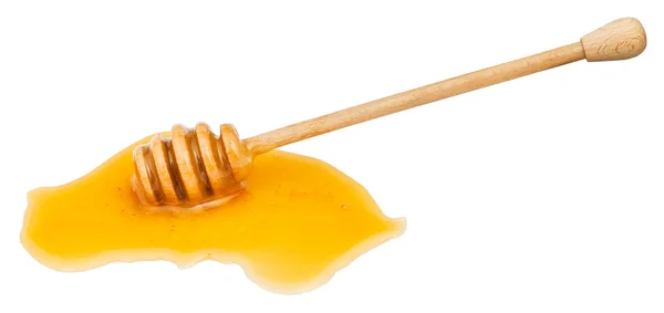 Puddle of clear honey and wooden spoon isolated — Stock Photo, Image