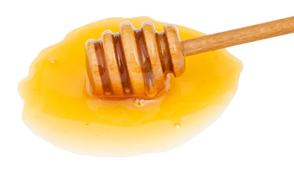 Pöl av tydliga honung och träpinne närbild — Stockfoto
