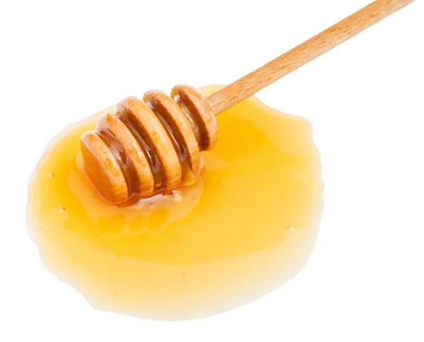 Pöl av transparent honung och stick på nära håll — Stockfoto