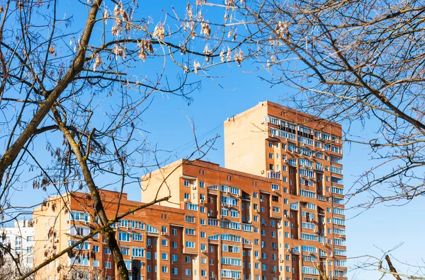 Bare tree branches, blue sky and apartment house — Stock Photo, Image