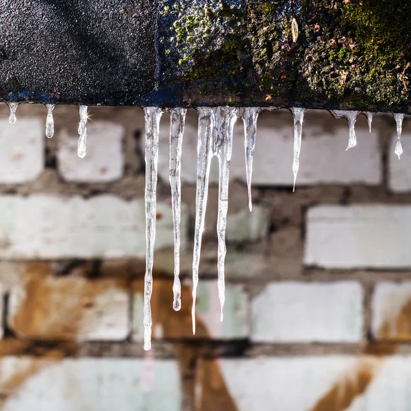 Evin tuğla duvar ile buz sarkıtları çatı hissettim — Stok fotoğraf