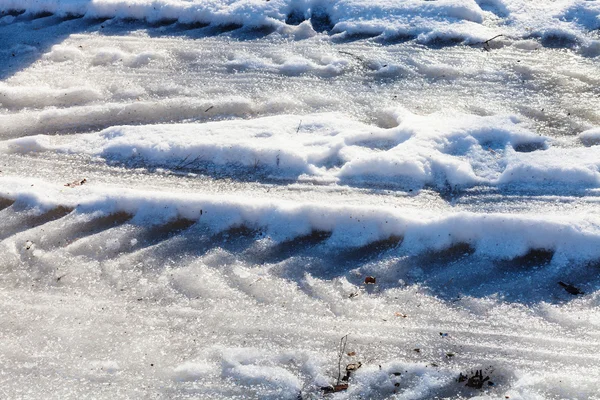 Sentiers de voitures gelées sur route de campagne enneigée — Photo