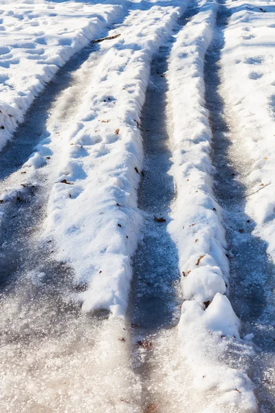 Pistas de coches congelados en carretera nevada país — Foto de Stock