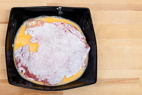 그릇에 계란과 밀가루에 빵 가루 입힌 송아지 고기 슈니첼 — 스톡 사진