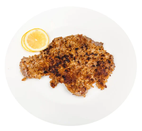 Escalope de ternera frita y rodajas de limón en el plato — Foto de Stock