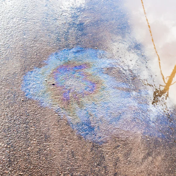 Iridescent film of engine oil on asphalt pavement — Stock Photo, Image