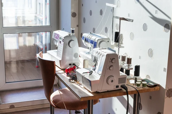 Швейные машины и сергер на столе — стоковое фото
