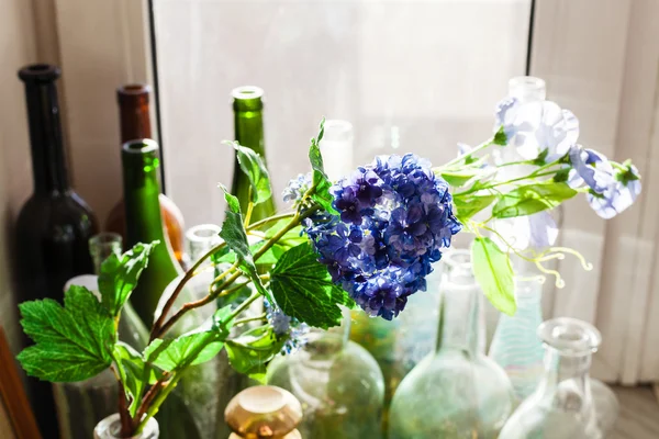 Textiel kunstmatige bloemen en oude flessen — Stockfoto